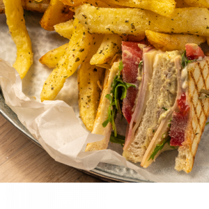 Club Sandwich with chicken salad, tomato, lettuce, graviera cheese, pork shoulder and French fries