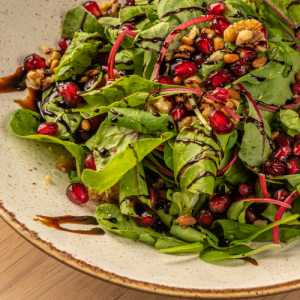 Green salad with cornsalad, beetroot leaves, spinach,pomegranate seeds, walnuts, pine nuts and garlic-flavored dressing