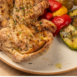 Crispy grilled half of an organic chicken with grilled vegetables