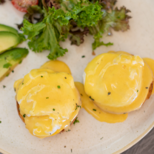 Benedict with poached egg, avocado, melted Cheddar cheese and hollandaise sauce