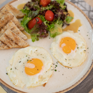 Sunny-side-up eggs (2 eggs) with toasted bread and mixed salad