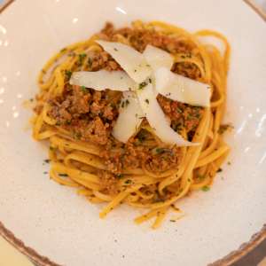 Spaghetti bolognese with 100% ground beef and fresh tomatoes, served with parmesan flakes