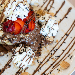 Pancakes with hazelnut praline, ground biscuit, almond and hazelnut, fresh fruits and whipped cream