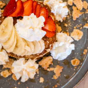 Pancakes with maple syrup or honey, hazelnut croquant, fresh fruits and whipped cream