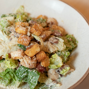 Caesar's salad with chicken, bacon, croutons and anchovy sauce