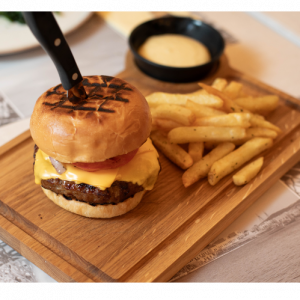 Burger with brioche bun, Black Angus minced meat, caper mayonnaise cheddar, tomato, caramelized onions and French fries